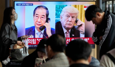 People watch a TV screen showing images of South Korea’s acting president, Han Duck-soo, and America’s president, Donald Trump