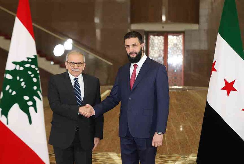 In this photo released by the Lebanese Government press office, Lebanese Prime Minister Nawaf Salam, left, shakes hands with Syrian interim President Ahmad al-Sharaa in Damascus, Syria, Monday, April 14, 2025. (Lebanese Government press office via AP)