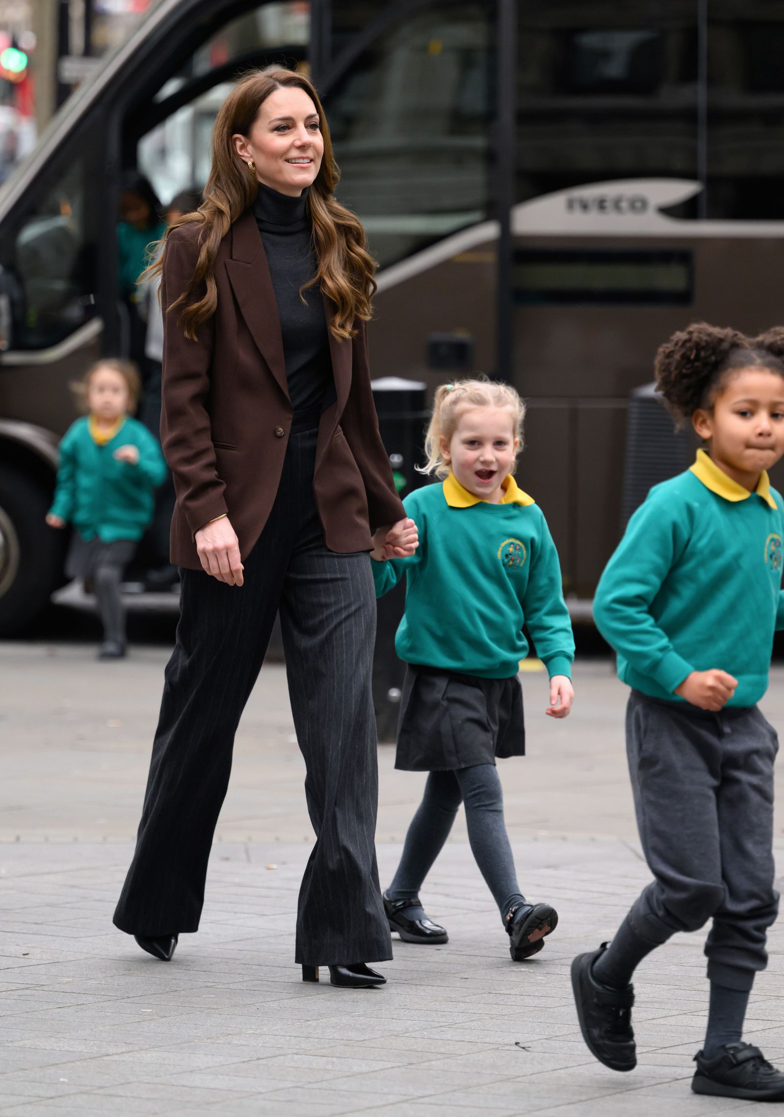 Image may contain People Person Walking Clothing Footwear Shoe Pants Adult Pedestrian Child High Heel and Coat