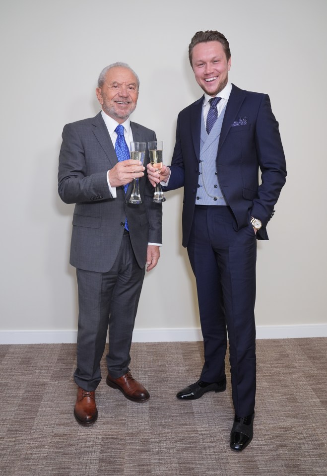 Lord Sugar and Dean Franklin toasting with champagne flutes.