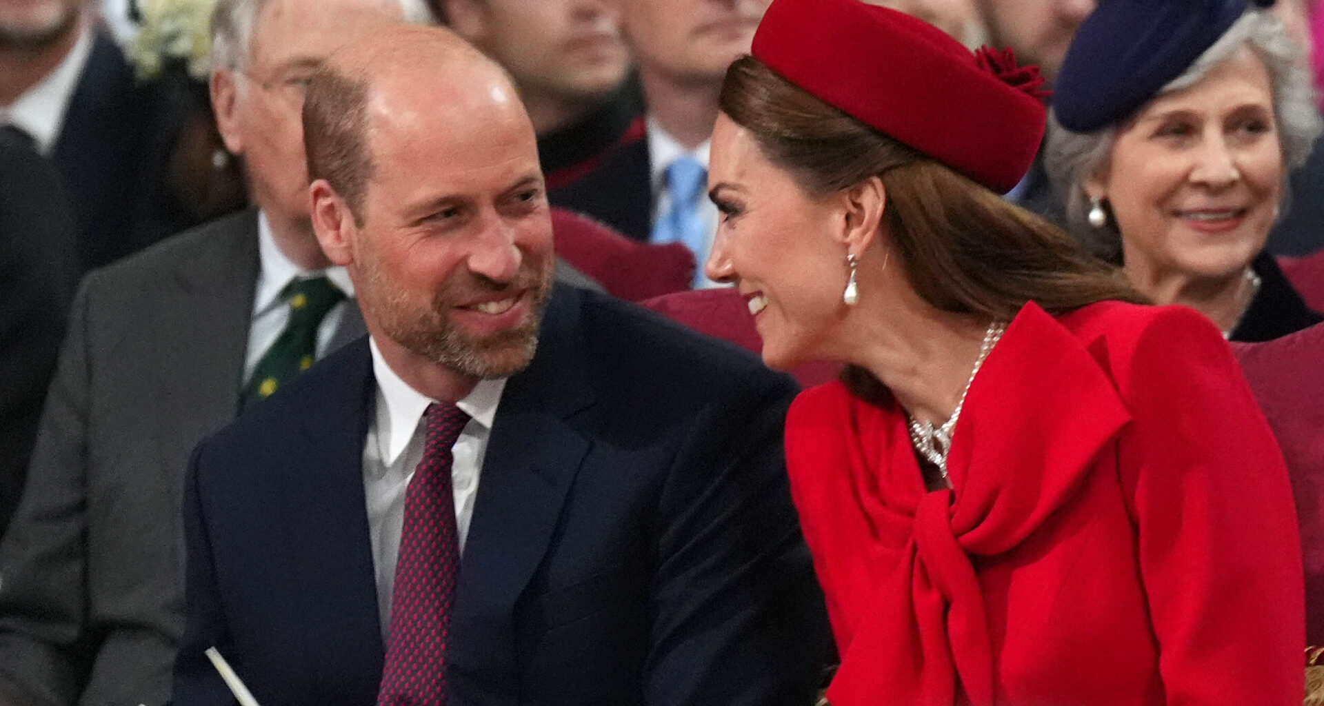 Kate Middleton and Prince William laughing and turning to smile at each other