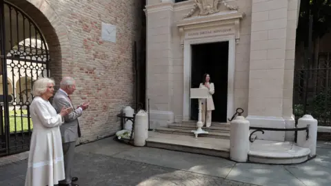 EPA The King and Queen stand clapping outside the tomb of celebrated Italian poet Dante Alighieri. 