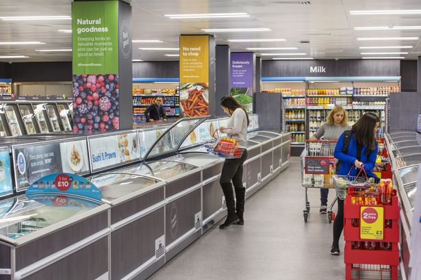 Interior aisle of Iceland with shoppers browsing 