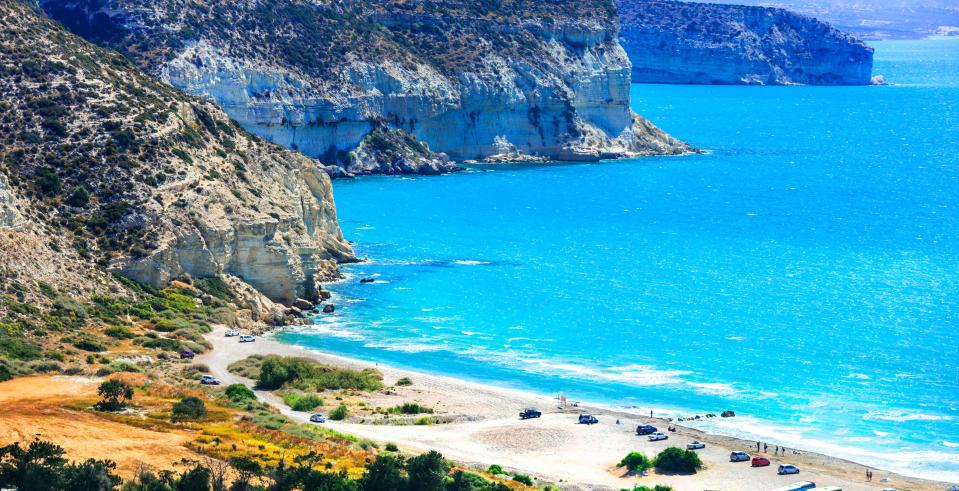 Kourion beach in Cyprus, with turquoise water and white cliffs.