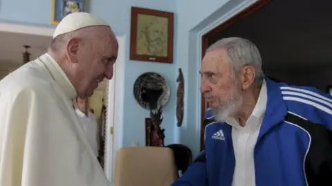 Reuters Pope Francis and former President Fidel Castro. Pope Francis is dressed in papal white and Castro is dressed in adidas sports wear.
