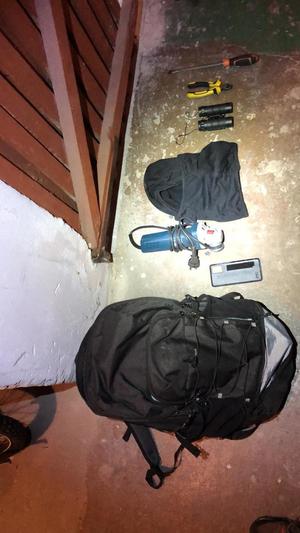 Przedmioty leżące na podłodze w postaci czarnego plecaka,telefonu, kominiarki,lornetki i narzedzi