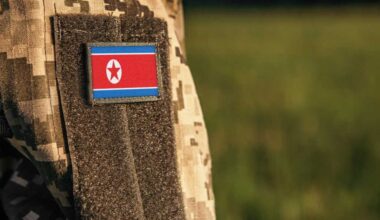 Close up millitary woman or man shoulder arm sleeve with North Korea flag patch. Troops army, soldier camouflage uniform. Armed Forces, empty copy space for text
