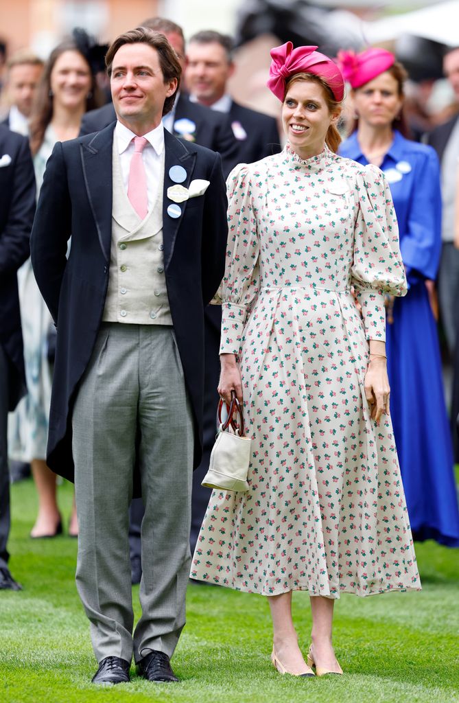 Edoardo in a morning suit and Beatrice in a floral dress with pink fascinator standing side by side attending royal ascot