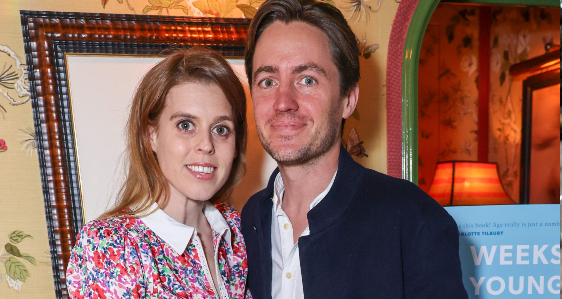 Princess Beatrice wearing a floral dress smiling and standing next to Edoardo Mapelli Mozzi