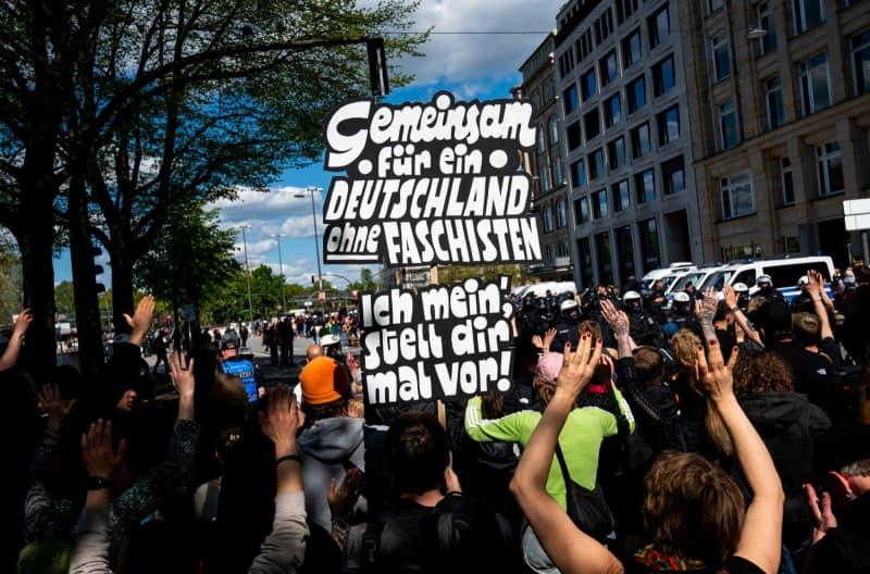 Participants in an anti-right-wing demonstration march through the city center holding a sign that reads "Together for a Germany without fascists. I mean, imagine that!", to protest against the right-wing nationwide demonstrations "Together for Germany". Daniel Bockwoldt/dpa