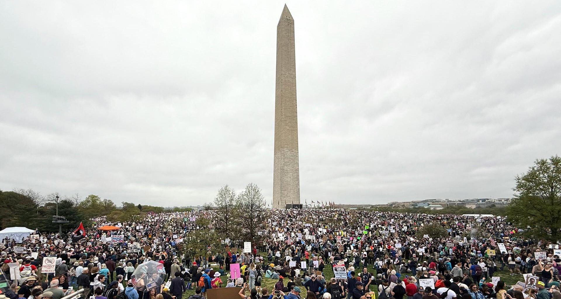 Blick auf tausende Demonstranten. Im Hintergrund der schmale und hohe Obelisk, der in den bewölkten Himmel ragt.