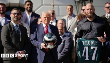 US President Donald Trump holds a helmet as he poses with Philadelphia Eagles head coach Nick Sirianni and offensive tackle Lane Johnson at an event welcoming the 2025 Super Bowl Champion Philadelphia Eagles on the South Lawn of the White House