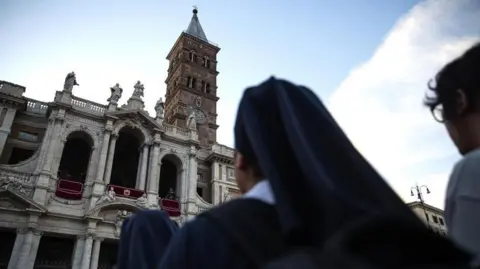 EPA A nun looking up at Santa Maria Maggiore