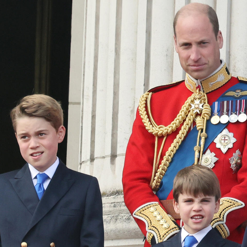 Kate Middleton wears a white dress with navy accents and a matching hat as she joins her husband, Prince William, on the Buckingham Palace balcony.