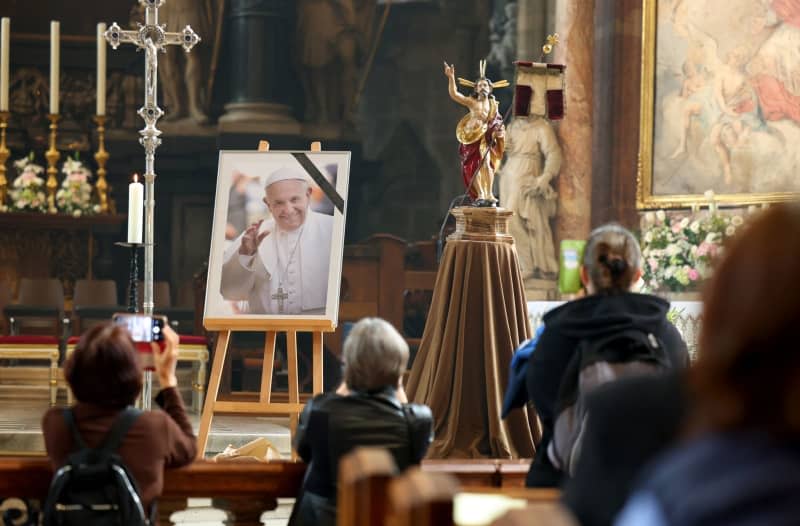 A picture of Pope Francis is displayed inside St. Stephen's Cathedral in Vienna, where people gather to attend a mass following the announcement of his death. The Argentine pontiff, who led the Catholic Church since 2013, passed away on April 21, 2025, at the age of 88, leaving a lasting legacy among millions of faithful around the world. Tobias Steinmaurer/APA/dpa