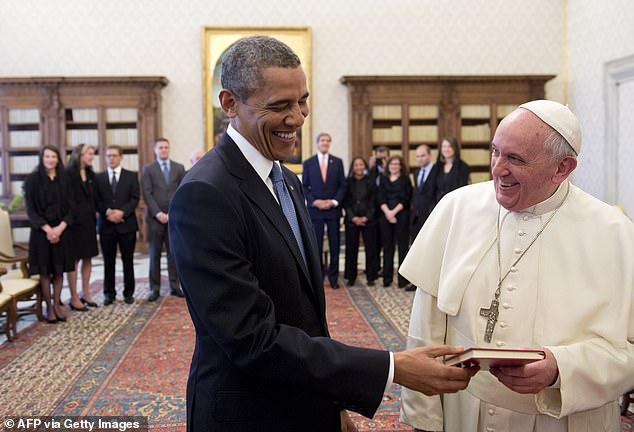 Pope Francis and US President Barack Obama laugh as they exchange gifts during a private audience in 2014