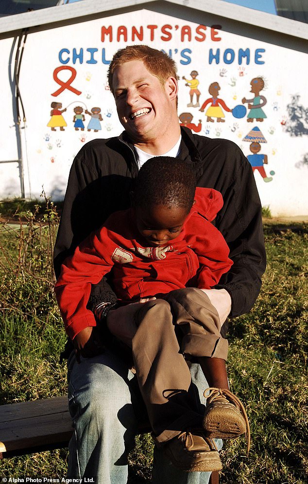 Prince Harry giggles as he holds old friend Mutsu Potsane, six, in the grounds of the Mants'ase childrens home, while on a return visit to Lesotho in 2006 as he set up Sentebale