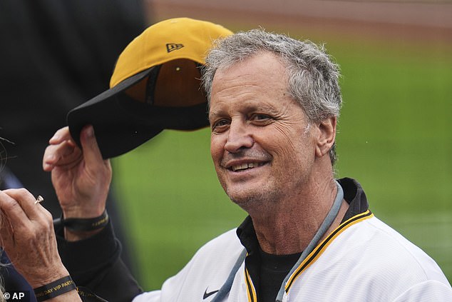 Marc Fogel, a US man who was detained in Russia and freed in a prisoner exchange in February, puts on his cap before throwing out a ceremonial first pitch before the Pittsburgh Pirates' home opener baseball game, Friday, April 4, 2025