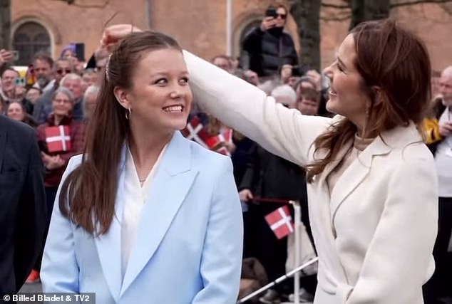 Queen Mary of Denmark reached out to fix her daughter's hair in a sweet moment captured on film - as Princess Isabella prepared to celebrate her 18th birthday