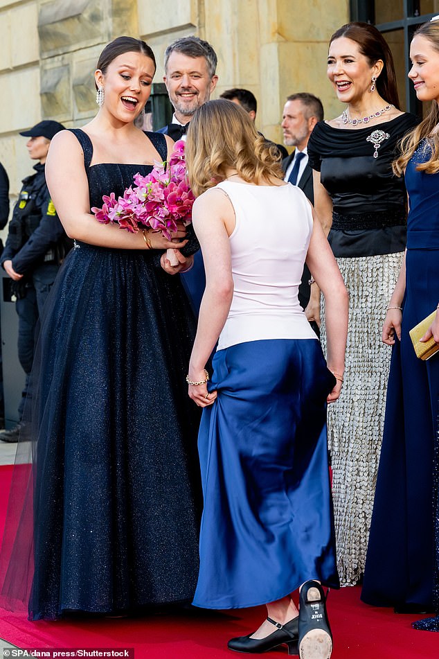 Princess Isabella beamed as she received a bouquet of bright pink flowers before heading into the event