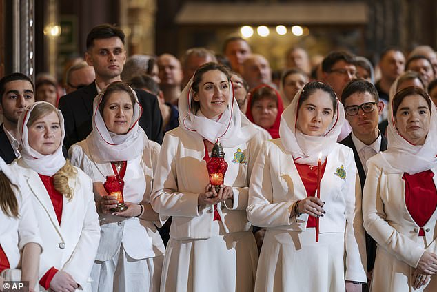 Young women hold candles while attending the Orthodox Easter service at Christ the Saviour Cathedral in Moscow