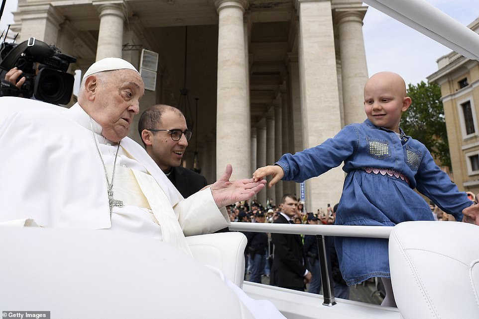 Pope Francis greets a little girl during the Easter Mass in St. Peter's Square a day before his death was announced by the Vatican