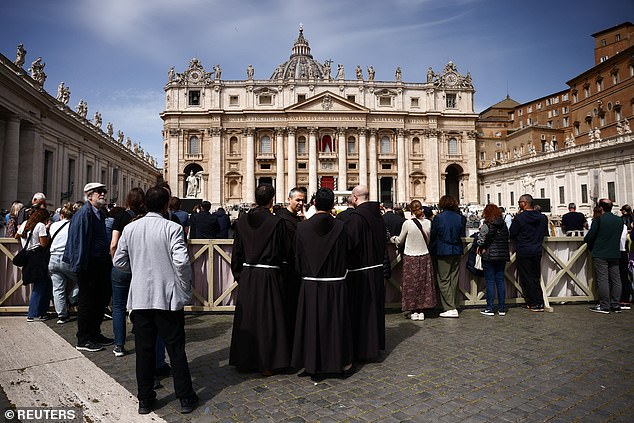 Clergy members stand in St. Peter's Square at the Vatican after the news broke, on April 21