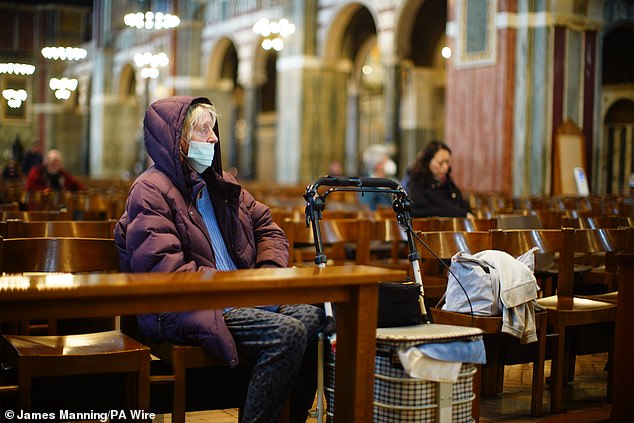 People sit in Westminster Cathedral in Victoria, London, following news of the Pope's death