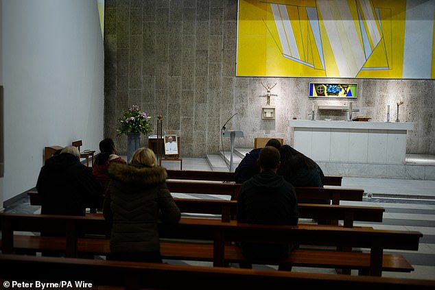 People pray at Liverpool Metropolitan Cathedral following the announcement