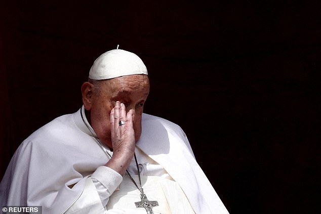 Pope Francis wipes his brow as he appears on the balcony of St Peter's basilica yesterday