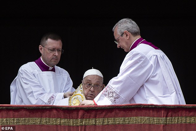 Aides are seen adjusting Pope Francis's cassock, a term that refers to the robes he wears, during the Urbi et Orbi blessing following the Easter Mass in Saint Peter's Square yesterday