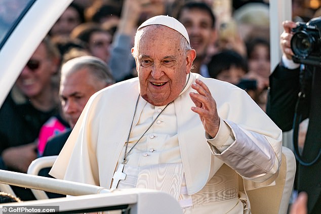 Pope Francis pictured smiling and waving to crowds in Ajaccio, the capital of the French island of Corsica, during a visit in December