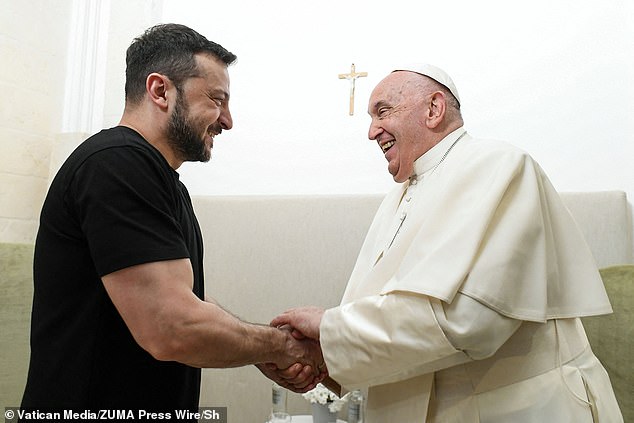 President Zelensky smiles as he and the Pontiff shake hands during a later meeting at a G7 summit in June last year