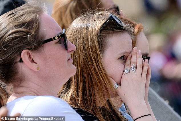 A mourner wipes her tears as she stands in the crowd assembled in St. Peter's Square today