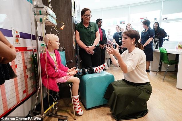 Princess Eugenie opted to wear a khaki satin skirt and white jumper for the visit on Wednesday as she chatted with cancer patients and staff