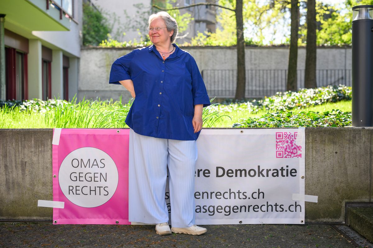 Rosmarie Brunner von Omas gegen Rechts, in Blau gekleidet, lehnt an einem Banner mit Aufschrift ’Omas gegen Rechts’ in Basel am 5. April 2025.