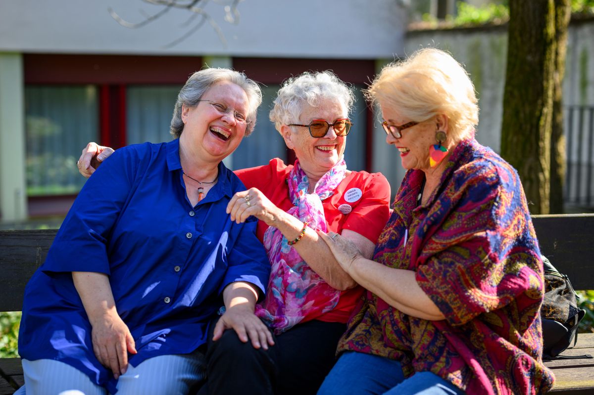 Rosmarie Brunner in Blau, Monika Salzer mit Ohrring und Dörte Schnell in Rot von Omas gegen Rechts lachen gemeinsam auf einer Bank in Basel am 5. April 2025.