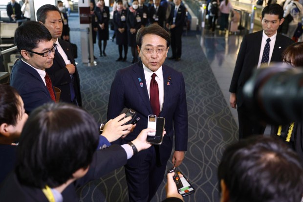 Japan's chief trade negotiator and Economic Revitalization Minister Ryosei Akazawa, center, speaks to the reporters before this departure for the U.S., at Haneda airport in Tokyo, Wednesday, April 16, 2025. 