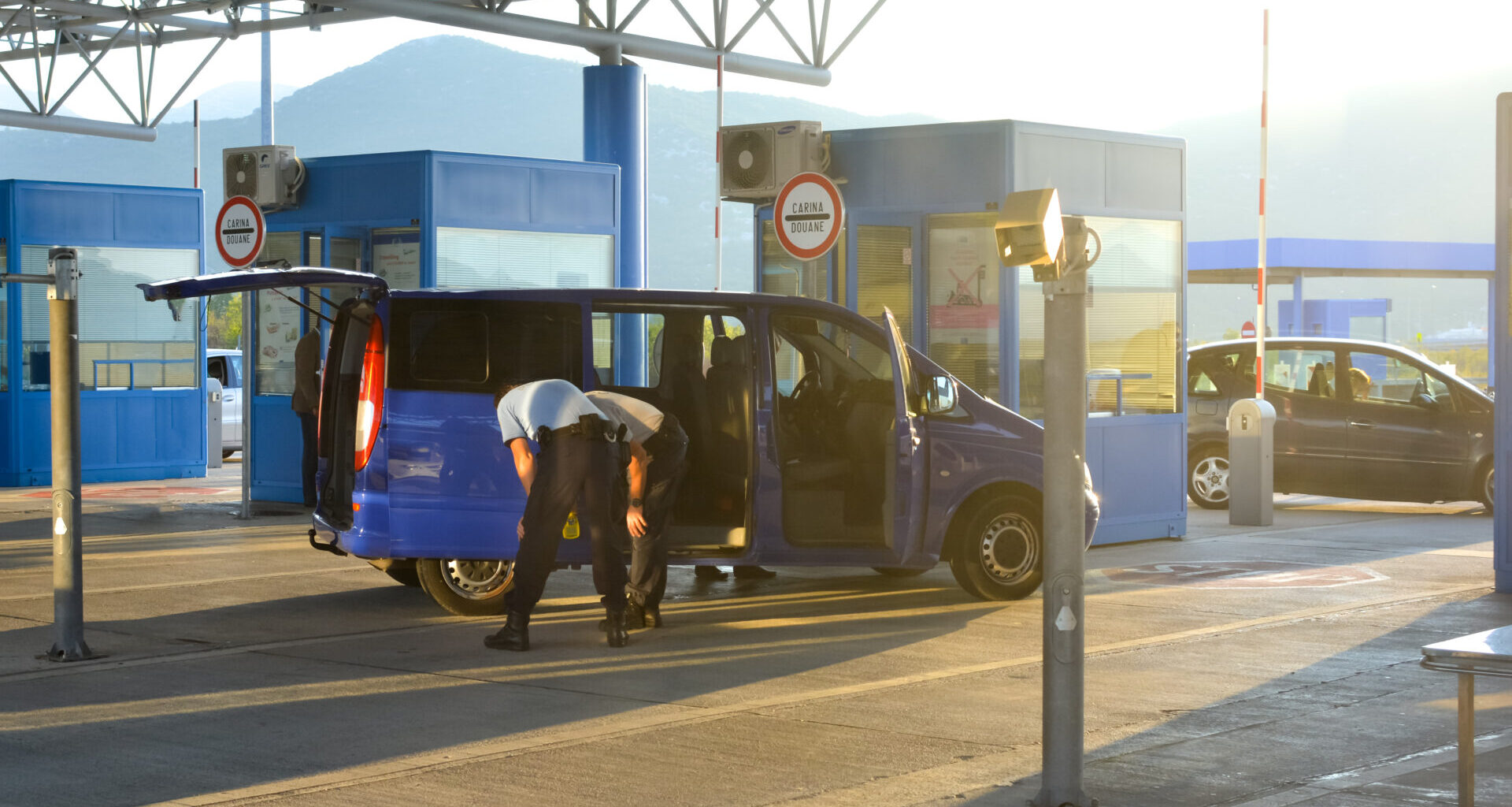 A van is stopped and checked by two inspectors at the border crossing at Ivanica between Bosnia and Herzegovina and Croatia.