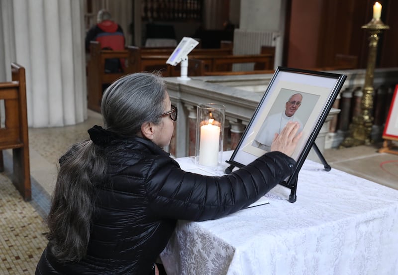 Rosane Zucconi paying her respects to the late Pope Francis at St Mary's Pro Cathedral, Dublin, on Tuesday morning, at a table holding the book of condolences and a portrait. Photograph: John Mc Elroy