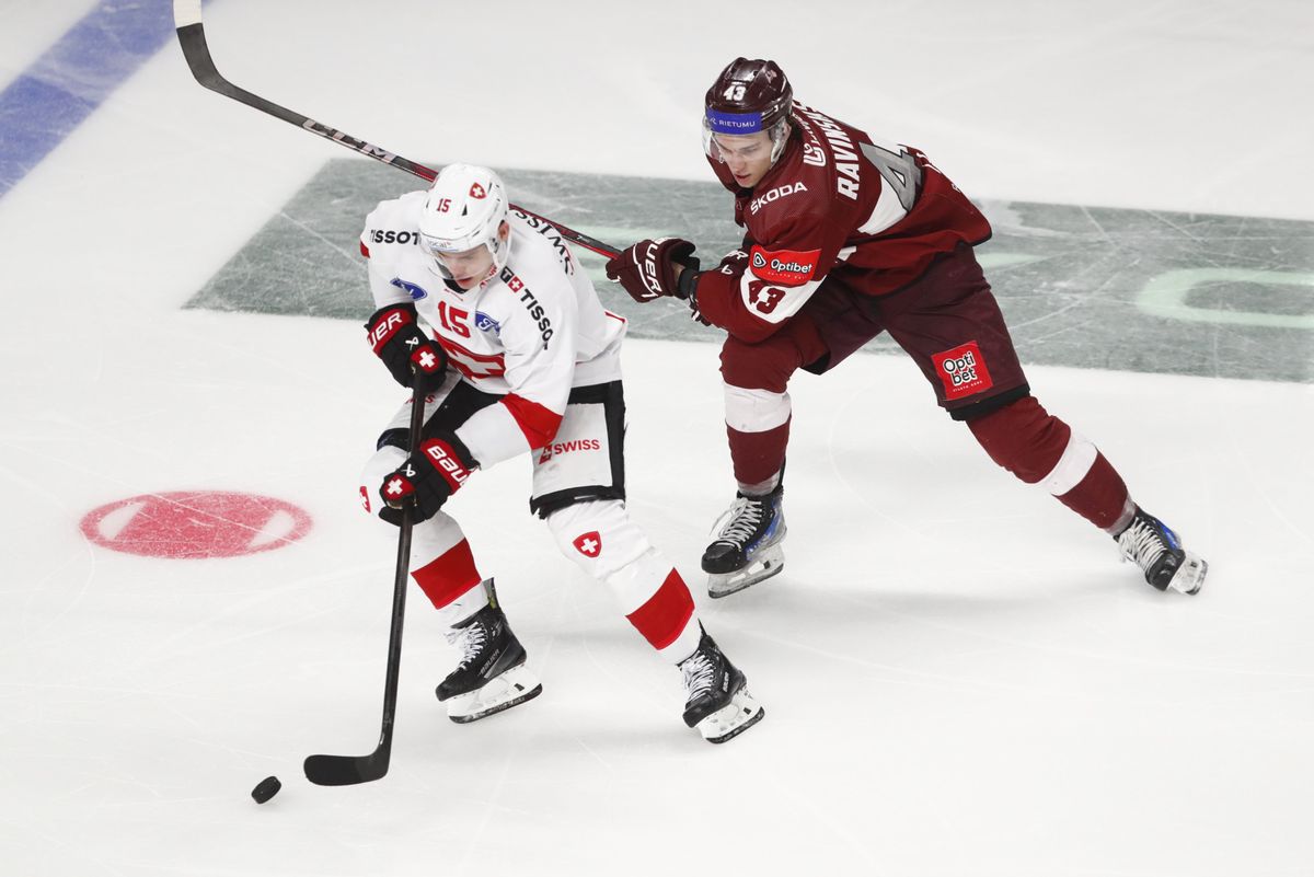 Anri Ravinskis de la Lettonie défie Grégory Hofmann de la Suisse lors d’un match amical de hockey sur glace à Riga, Lettonie, le 25 avril 2025.