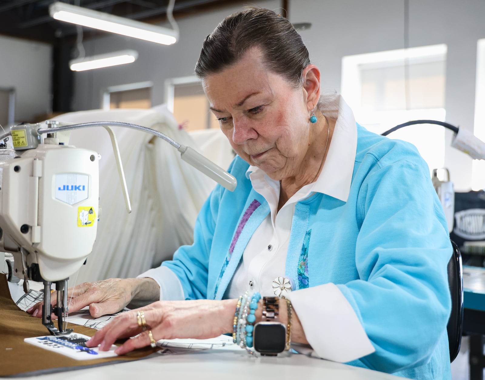 Linda Tipton, a volunteer for Dayton Sewing Collaborative, sews a patch on a gift bag that will be given to NATO Parliamentary Assembly Spring Session participants in May. The bags were unveiled during a news conference on Monday. BRYANT BILLING / STAFF