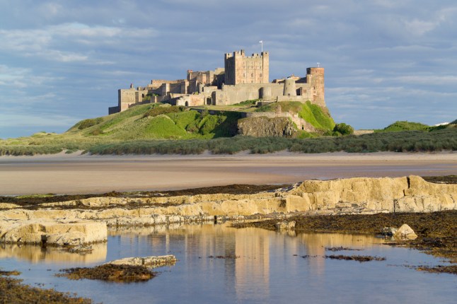 UK, England, Northumberland, Bamburgh Castle on hill near beach