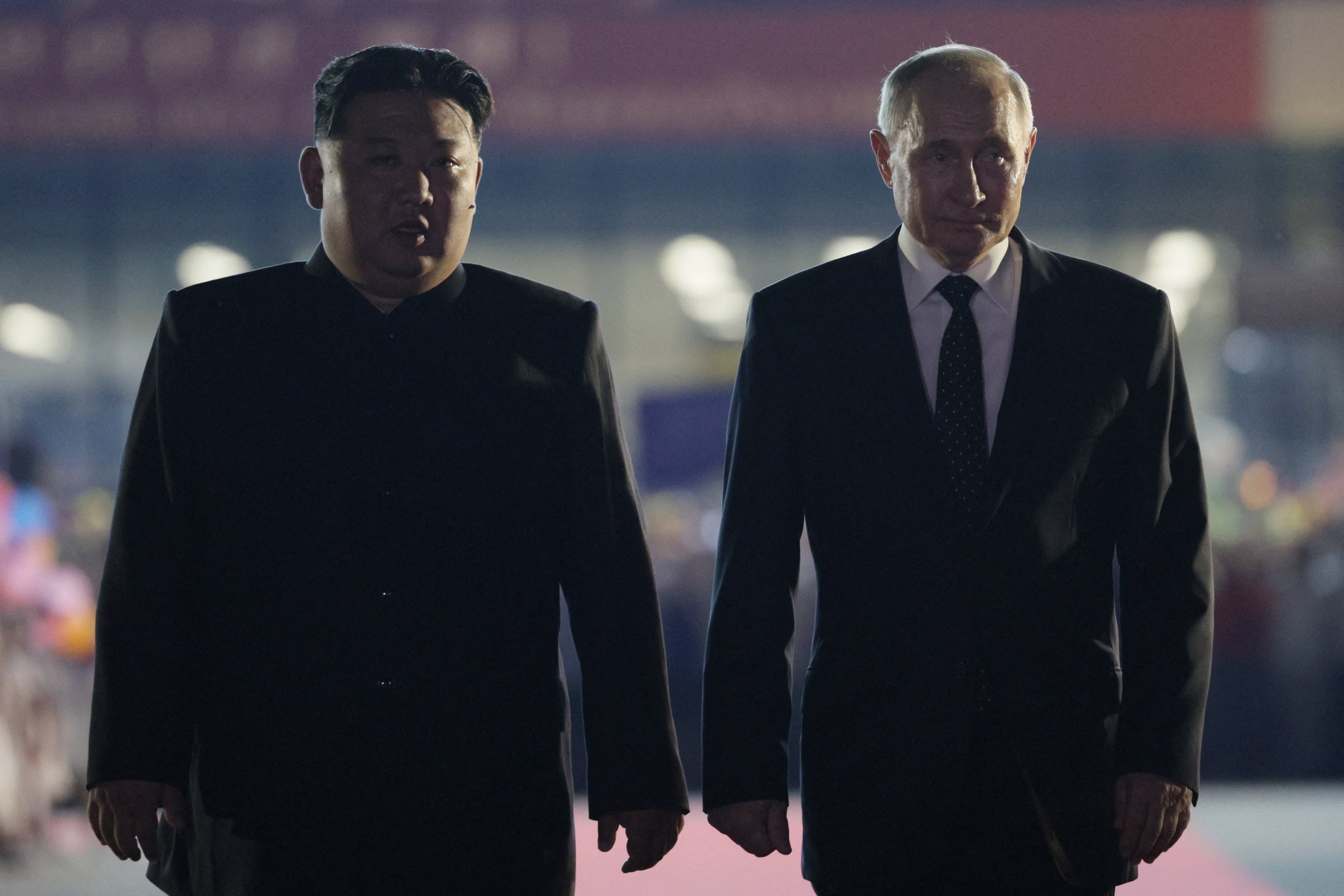 Russian president Vladimir Putin (R) and North Korean leader Kim Jong Un walk during a farewell ceremony upon Putin's departure at the Sunan International Airport in Pyongyang