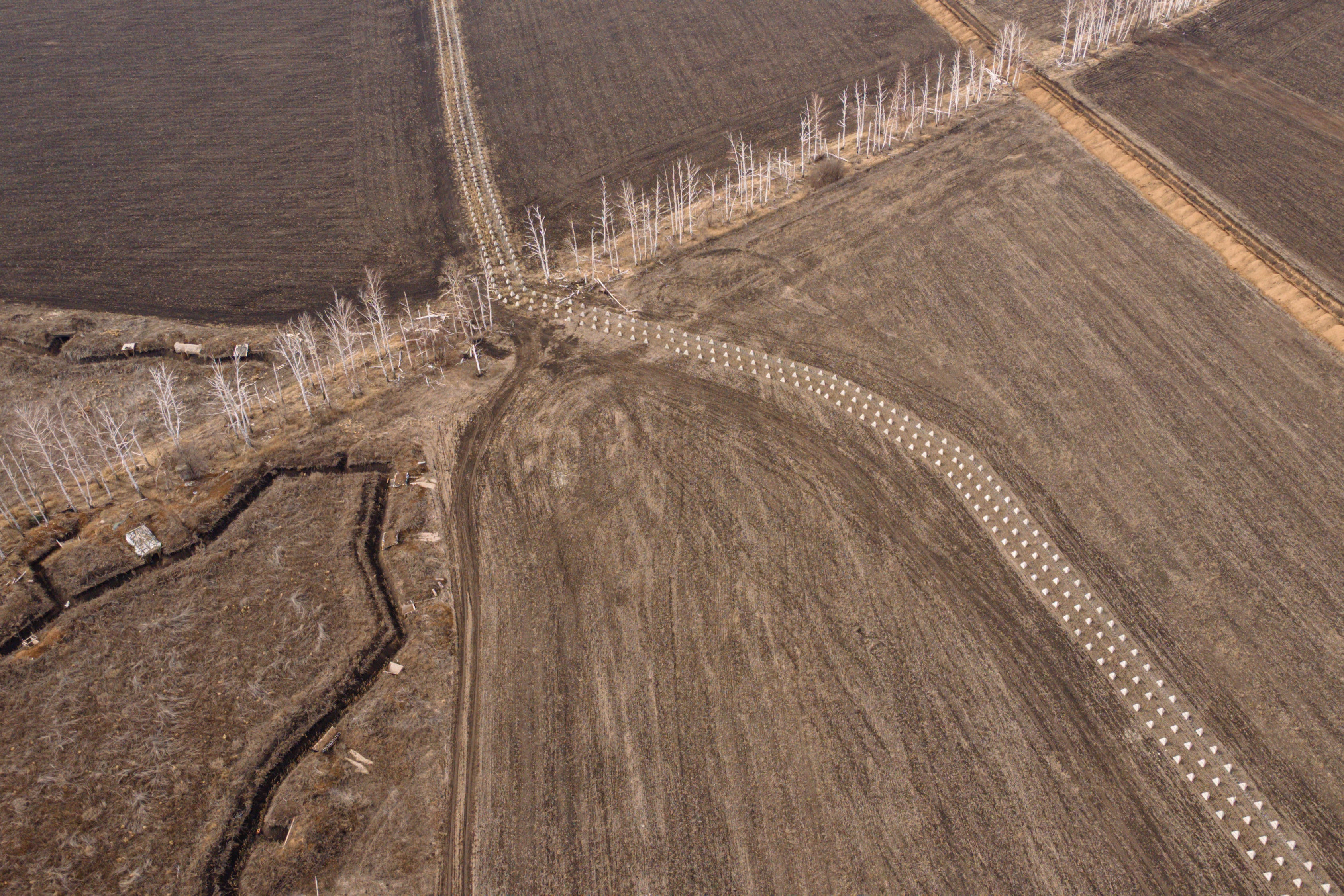 Barbed wire and dragon's teeth anti-tank obstacles are seen along a fortification line in the Kharkiv region of Ukraine