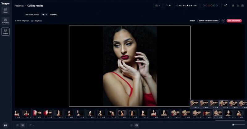 A woman with long, curly hair poses dramatically. She wears a red strappy top and has red lipstick. Her hands are gently framing her face. The background is dark, emphasizing her features.