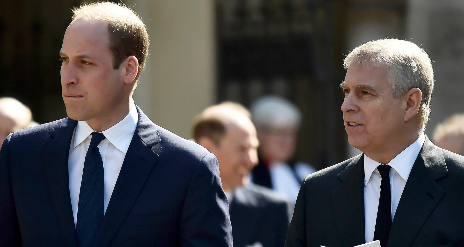 Prince William and Prince Andrew wearing suits holding programs at a church service