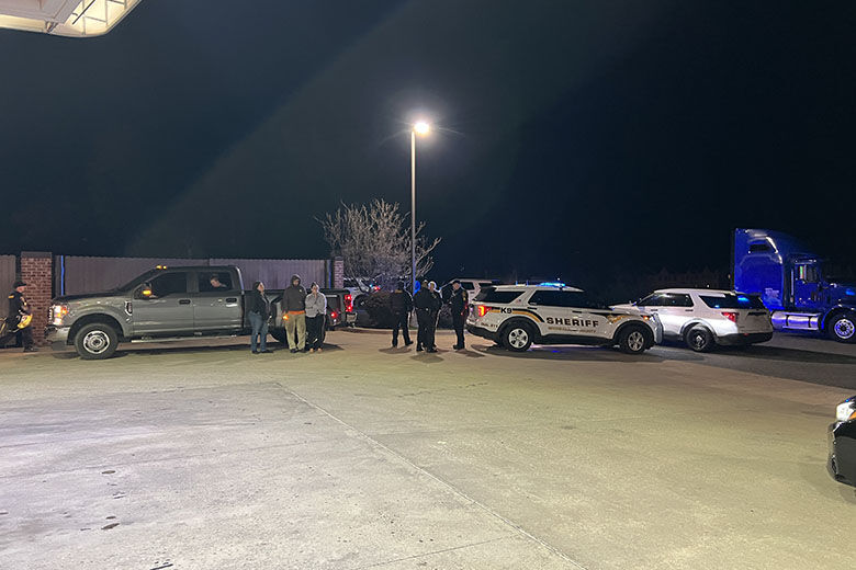 Law enforcement officials and residents stand outside of a convenience store near the scene of a mass shooting in Spotsylvania County, Virginia, on April 8, 2025.