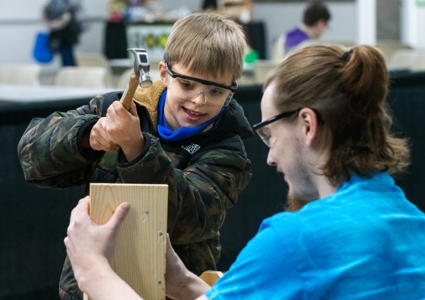 Volunteer Vinnie Gordon keeps a firm grip as Walter Bryant, 8, uses a hammer to finish the bird house he built during the 2025 Northwest Indiana Earth Day celebration at the Porter County Expo Center in Valparaiso, Indiana, Saturday, April 12, 2025. (Andy Lavalley/for the Post-Tribune)