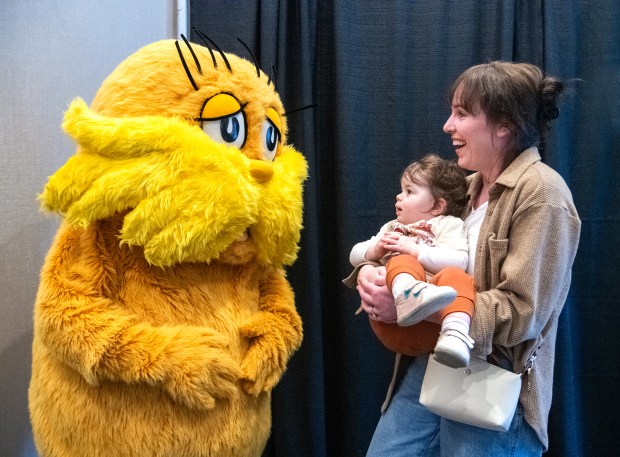 Amanda Pucher and her 1-year-old daughter Savannah smile during a visit with The Lorax at the 2025 Northwest Indiana Earth Day celebration at the Porter County Expo Center in Valparaiso, Indiana, Saturday, April 12, 2025. Pucher was doubly interested as it was her sister, Ayla Brown, playing the popular Dr. Seuss character. (Andy Lavalley/for the Post-Tribune)